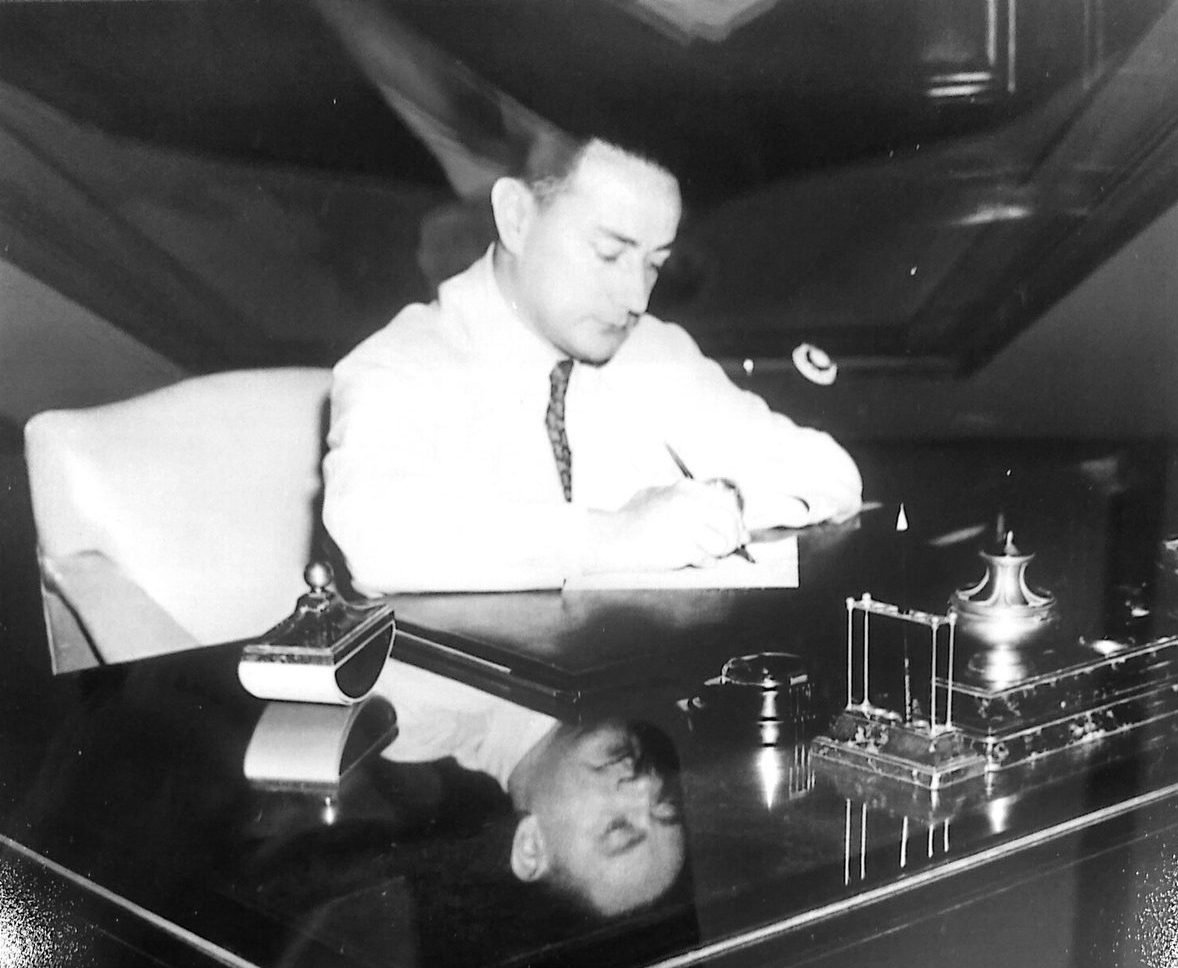 Carlos A. Pedretti escribiendo en su despacho, fotografía en blanco y negro